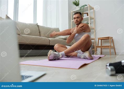 Man Sports Watching Tape Of Workout On Phone And Repeating Exercises