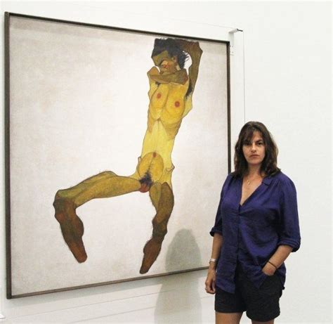 A Woman Standing In Front Of A Large Painting On Display At An Art