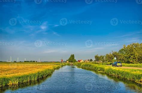 Dutch Landscape With A Canal And Grass Fields With Mirror Reflec