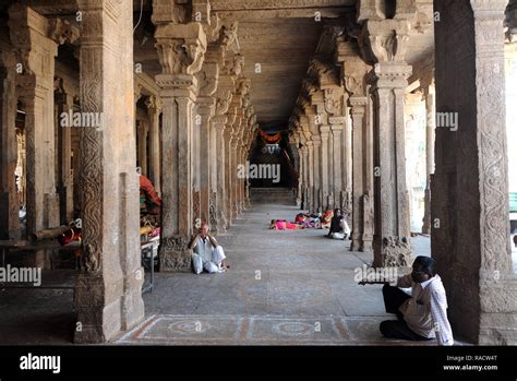 People resting in the stone pillared corridor inside the 11th century Brihadisvara Cholan temple ...