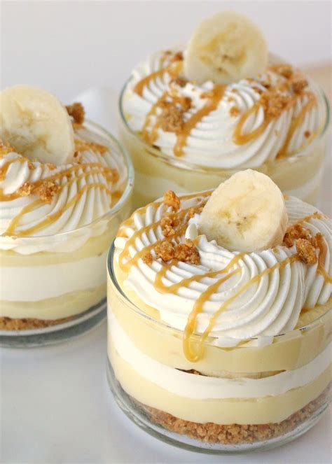 Three Desserts With Banana Slices And Whip Cream On Top Are Sitting On