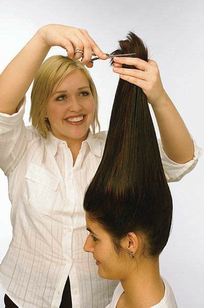 A Woman Is Cutting Her Hair With A Pair Of Scissors While Another Woman