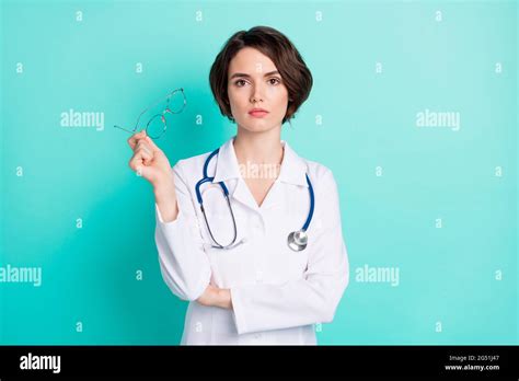 Photo Portrait Of Serious Nurse Wearing White Uniform Keeping Glasses Isolated Bright Teal Color