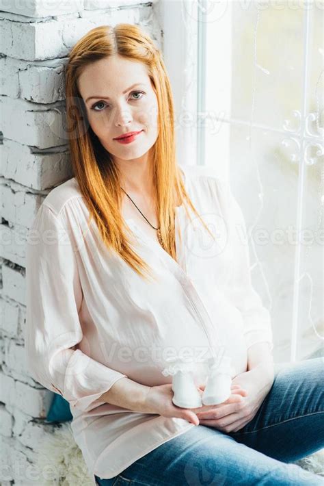 Red Haired Pregnant Girl In A Light Blouse And Blue Jeans 18921036