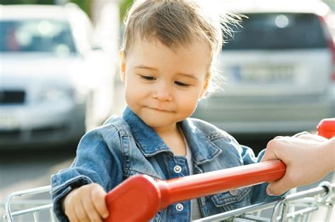 Menino Bonitinho Sentado Em Um Carrinho De Compras Foto Premium