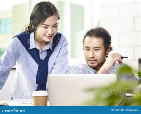 Asian Business Man And Woman Working Together In Office Stock Image