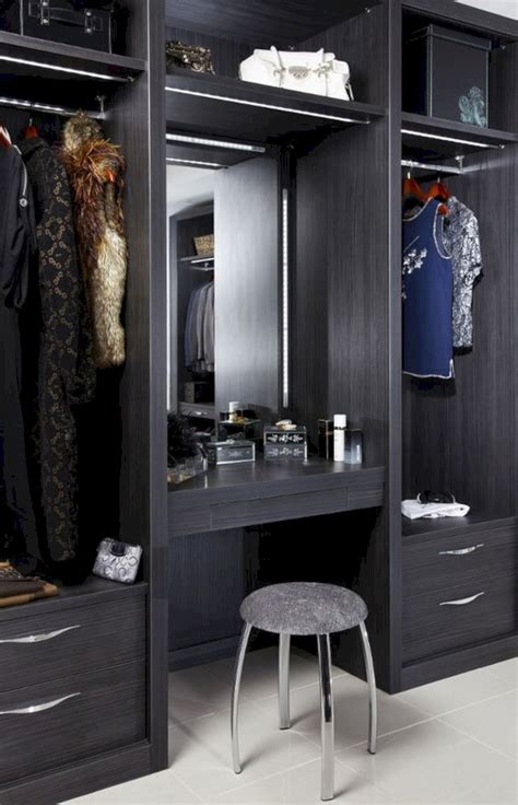 An Open Closet With Clothes Hanging On The Shelves And Stool In Front Of It