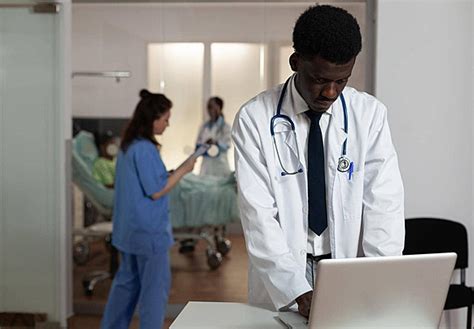 African American Doctor Posing At A Desk In A Hospital Ward Photo