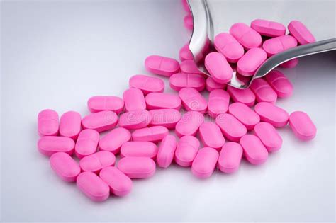 Pile Of Pink Tablets Pill On White Background Near Stainless Steel Drug