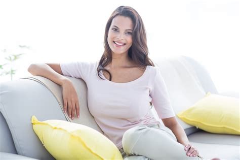 Premium Photo Smiling Beautiful Brunette Relaxing On The Couch And Looking At Camera