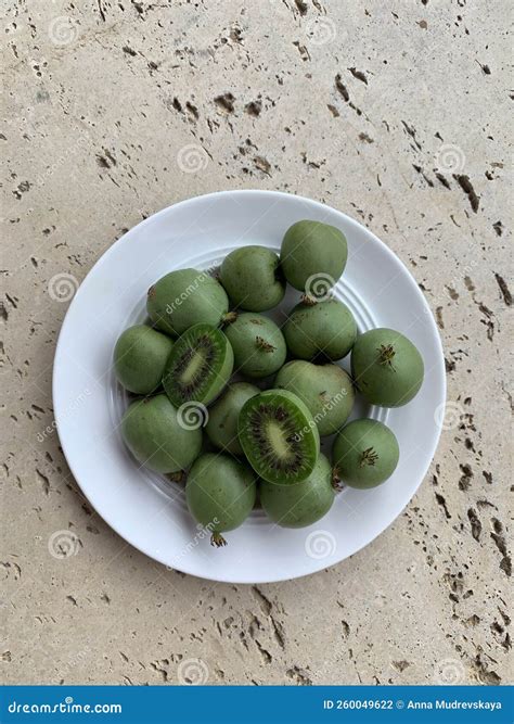 White Plate With Whole And Halves Green Kiwis Or Mini Kiwis On A