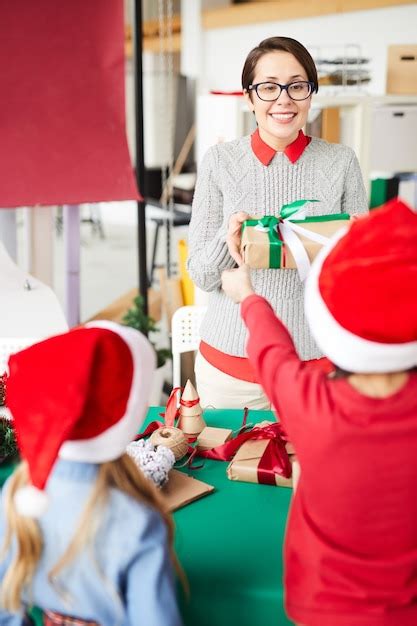 Mãe e filhos felizes trocando presentes de natal Foto Grátis