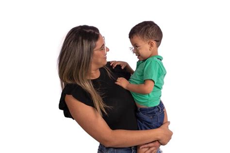 Mère blonde avec son fils dans ses bras portant des lunettes en studio photo avec un fond blanc