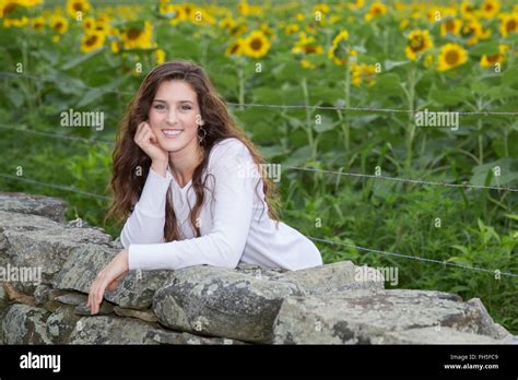 Beautiful Brunette Woman Out In Nature With Sunflowers Stock Photo Alamy