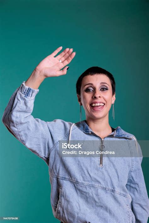 Smiling Happy Woman Waving With Palm At Camera Having Fun In Studio