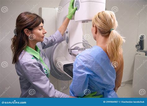 Experienced Radiologic Technologist Preparing Female For Mammogram