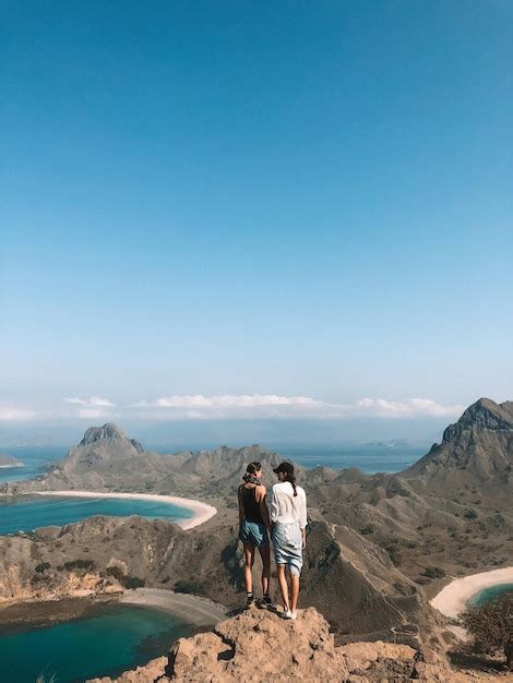 Premium Photo Full Length Of Women Standing On Mountain Against Blue Sky