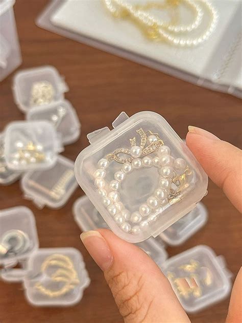 A Hand Holding A Plastic Container Filled With Jewelry