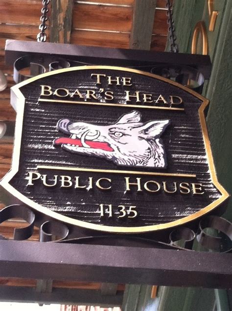 A Sign For The Boar S Head Public House Hanging From A Chain On A Building