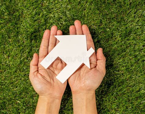 Hands Holding A House In Conceptual Image Of Plans For Housing