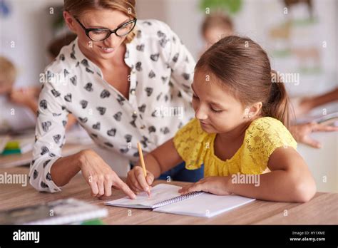 Cheerful Teacher Helping Her Student Stock Photo Alamy