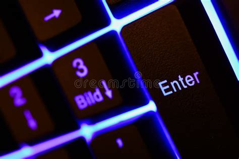 Macro Closeup Of Blue Illuminated Enter Key On Computer Keyboard Stock