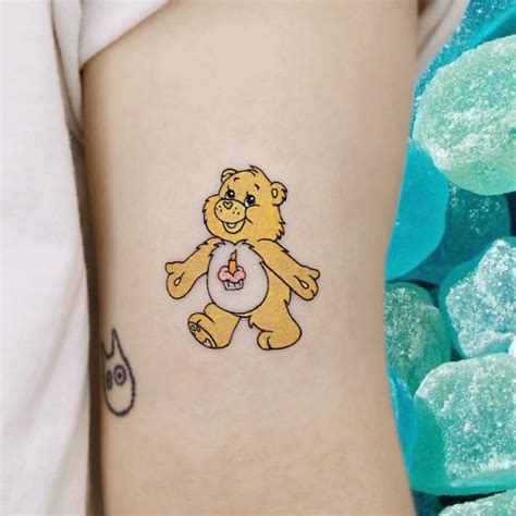 Cartoon style Care Bear tattoo located on the bicep.