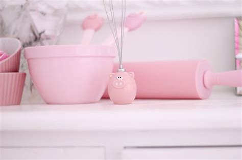 Pink Kitchen Accessories And Utensils On A White Counter