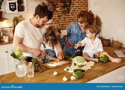 Familia Feliz Con Sus Hijos Cocinando En La Cocina Foto De Archivo