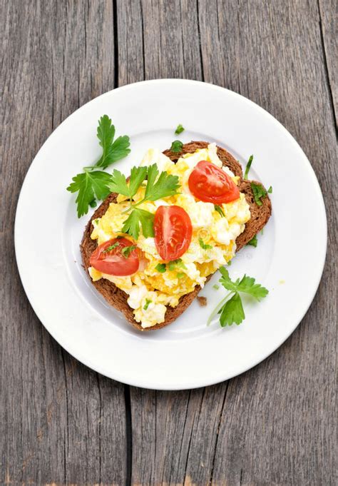 Bocadillo Con Los Huevos Revueltos Y El Tomatoe Imagen De Archivo