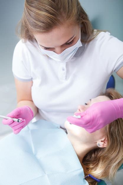 Foto Cortada Vertical De Uma Dentista Verificando Os Dentes De Uma