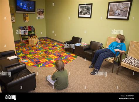 Two Boys Sitting In A Doctors Office Waiting Room Watching A Movie