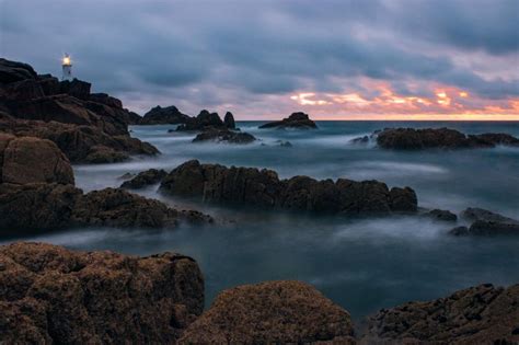 Free Stock Photo Of Lighthouse On Rocky Shore At Sunset Download Free