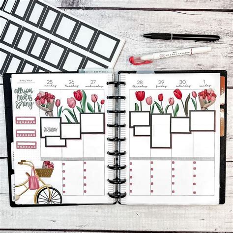 An Open Planner With Flowers On It Next To A Pen And Paper Clippings