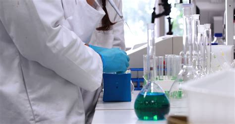 A Female Scientist Meticulously Conducts An Experiment In A Lab With