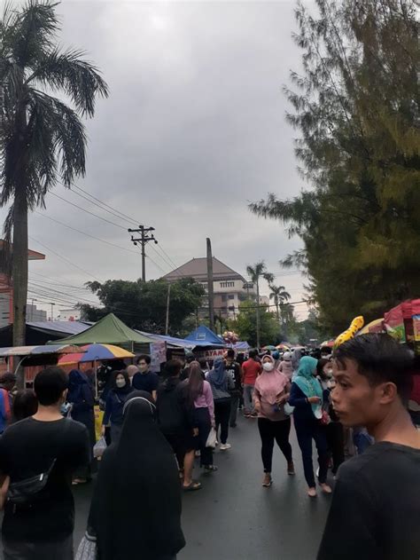 Many People Are Walking Down The Street With Umbrellas And Food Stalls