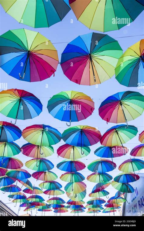 Low Angle Of Rainbow Color Umbrellas Hanging Over The Walkway Stock