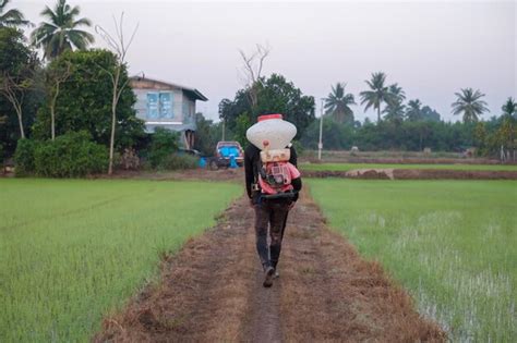 Premium Photo A Farmer From Asia Is Using A Knapsack Mist Duster To