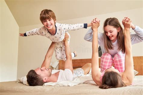 Les Parents Jouent Avec Leurs Enfants Au Lit Le Matin Image Stock