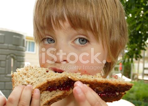 Little Girl Eating Peanut Butter And Jam Sandwich Stock Photo | Royalty ...