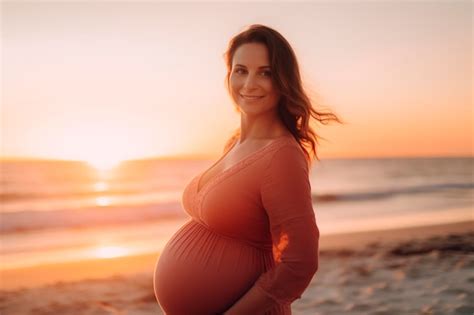 Premium Ai Image A Pregnant Woman Stands On The Beach In A Pink Dress