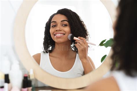 Mulher Negra Sorridente Aplicando Soro Hidratante à Cara E Olhando Para