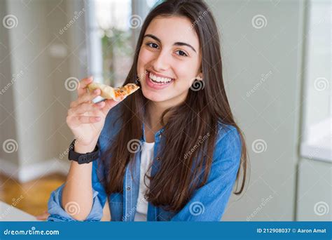 Beautiful Young Woman Eating A Slice Of Tasty Pizza With A Happy Face