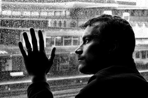 homme triste qui regarde la pluie tomber fenêtre FOTOMELIAFOTOMELIA