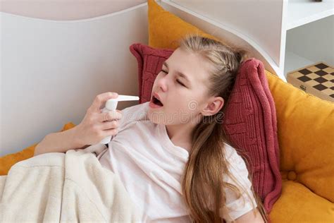 Girl Using Medical Spray Flying In Bed At Home Sore Throat Stock Image