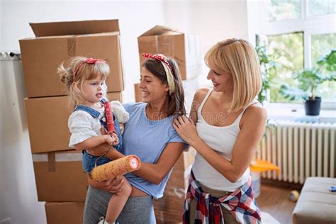 Feliz Hija Y Padres Gay En Casa De Una Nueva Familia Imagen De Archivo Imagen De Nuevo Padre