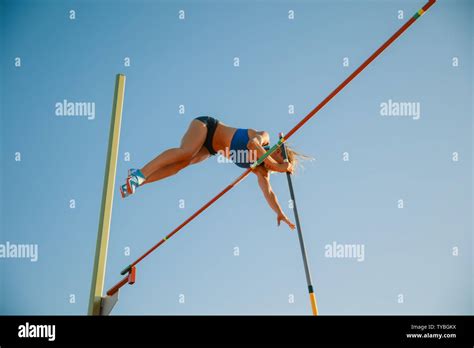 Professional female high jumper training at the stadium in sunny day ...