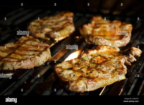 Four Porks Shoulder Steaks On The Barbeque Stock Photo Alamy