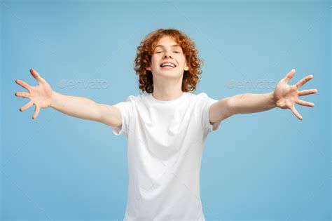 Red haired teenager male with braces, extending arms in welcoming hug ...