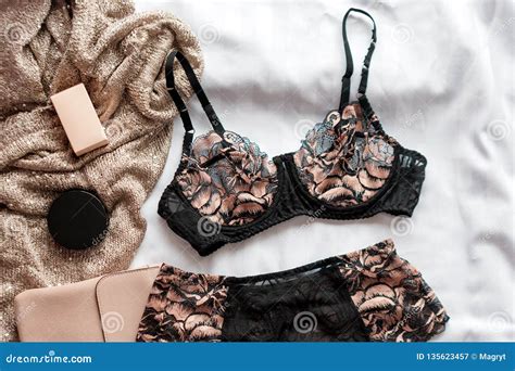 Set Of Glamorous Stylish Lace Lingerie With Woman Accessories On White Bedsheets Background